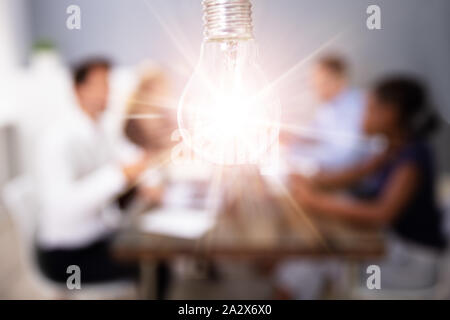Sur l'ampoule en face de personnes en réunion créative Banque D'Images