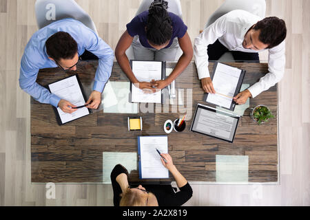 Groupe d'affaires d'une entrevue avec un jeune femme candidate In Office Banque D'Images