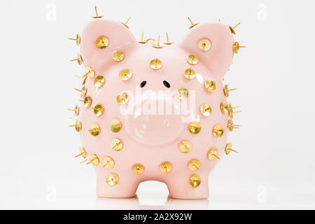 Image conceptuelle illustrant la protection des économies et des investissements montrant une banque de porc rose protégée par des piles de dessin et isolée contre le blanc. Banque D'Images