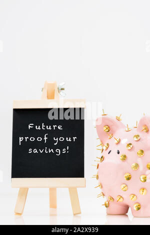 Image conceptuelle illustrant la protection des économies et des investissements montrant une banque de porc rose protégée par des piles de dessin et isolée contre le blanc. Banque D'Images