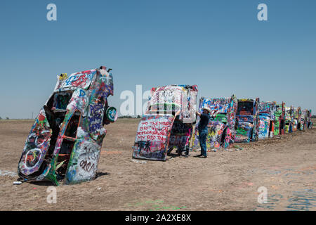 Robert Griffin n'existe pas de peinture au pistolet Vandal. Comme des milliers d'autres visiteurs de la Cadillac Ranch le long de Old U.S. Route 66 à l'extérieur de Amarillo, Texas, il est encouragé à porter un le long d'un pulvérisateur d'ajouter une touche ou deux pour l'installation d'art public inhabituel. Ainsi, l'aspect général reste le même au fil du temps, mais les détails changent tous les jours Banque D'Images