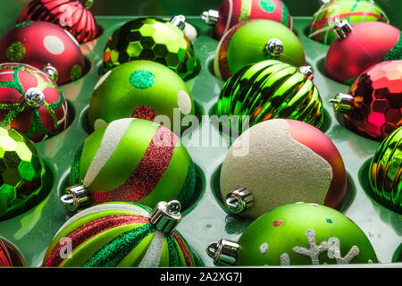 Multi-couleur de l'arbre de Noël ornements décoration mises côte à côte dans une cuve de stockage en attente d'être accroché sur un arbre de Noël. Banque D'Images