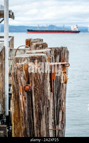 Old pier pourri pourri avec des pieux battus dans le fond de la baie et du métal rouillé pour un fonctionnement fiable des liens le jeu de pièces de la jetée à la bouche Banque D'Images