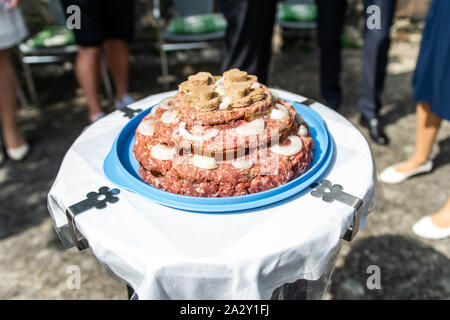 Gâteau de mariage matières Atriaux cuisine porc haché burgers sur un plateau en ardoise avec oignon, romarin, poivre et sel, servi sur un mariage close-up Banque D'Images