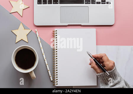 Bonne année 2020. Femme hand writing 2020 Buts en ordinateur portable. Décorations de Noël sur le fond tricolore. Haut de la vue, télévision lay, les frais généraux, l'exemplaire Banque D'Images