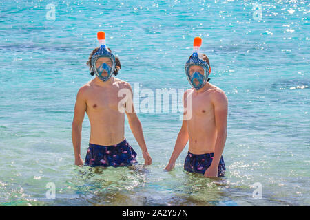 Deux jeunes hommes de race blanche portant des masques de plongée en mer Banque D'Images