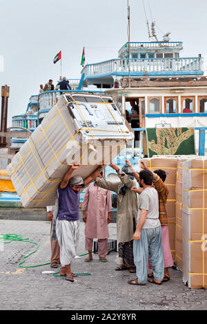 Les gens passe avec leur vie de tous les jours dans la vieille ville de Dubaï le chargement des cargos dans le port Banque D'Images