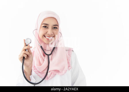 Portrait d'une belle jeune femme médecin musulmane portant un stéthoscope et sourire permanent dans une salle d'examen à l'hôpital sur fond blanc. Banque D'Images