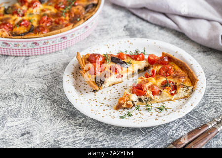 Quiche végétarienne tarte faite maison, avec des tomates cerises, aubergines et fromage feta sur un fond clair/ Banque D'Images