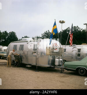 1970 Le camping. En photo une caravane Airstream dans l'aluminium et dans les années 1930, typiques de rationaliser la conception. La caravane a été conçu par Hawley Bowlus qui était inspirered par l'avion Spirit of St Louis. Dans le monde, les propriétaires de caravanes Airstream rencontrez et cette photo a été prise en Suède le 21 septembre 1971. Banque D'Images