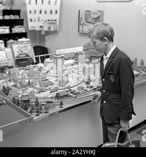 Les jouets dans les années 60. Un garçon est à la recherche d'un petit train monorail Alweg établisse, sur l'affichage à une exposition de jouets en Suède 1962 Banque D'Images