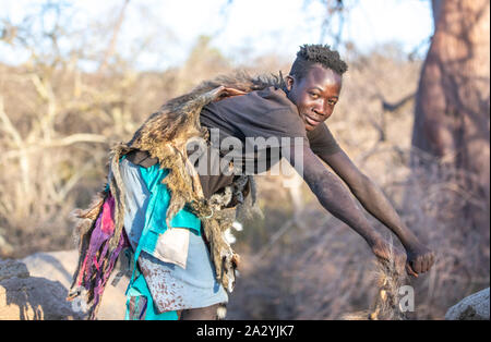 Lake Eyasi, Tanzanie, 11 Septembre 2019 : l'homme hadzabe montrant comment les babouins à pied Banque D'Images