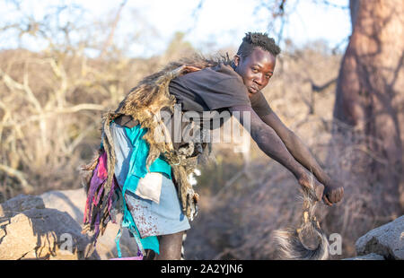 Lake Eyasi, Tanzanie, 11 Septembre 2019 : l'homme hadzabe montrant comment les babouins à pied Banque D'Images