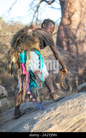 Lake Eyasi, Tanzanie, 11 Septembre 2019 : l'homme hadzabe montrant comment les babouins à pied Banque D'Images