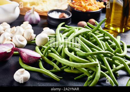 Ingrédients pour Thanksgiving classique. cocotte haricots verts frais dans un plat noir, oignons frits croustillants, fromage râpé, champignons sautés, ail Banque D'Images