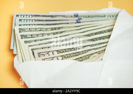 Close up beaux Dollars dans l'enveloppe sur un fond jaune. Cuisine américaine, US Dollars l'argent comptant. Une centaine de billets en dollars . Banque D'Images