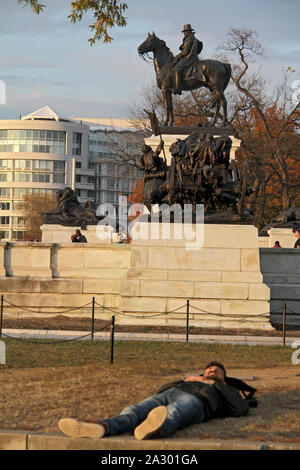 Jeune homme se reposant sur la pelouse en face de l'Ulysses S. Grant Memorial à Washington DC, USA Banque D'Images