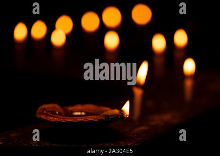 Diwali Diya lampe à pétrole et des bougies allumées pendant diwali festival en Inde avec des lumières bokeh isolé en fond noir. Stock photo pour diwali, temple, rel Banque D'Images