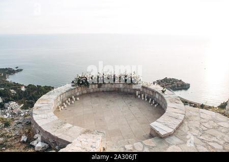 Décors de fleurs en préparation pour le mariage sur le fond de la mer et l'île de Sveti Stefan au Monténégro. Banque D'Images