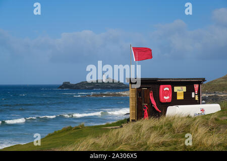 Red Flag flying au-dessus de la station de sauvetage de la RNLI à Cornwall Godrevy Banque D'Images