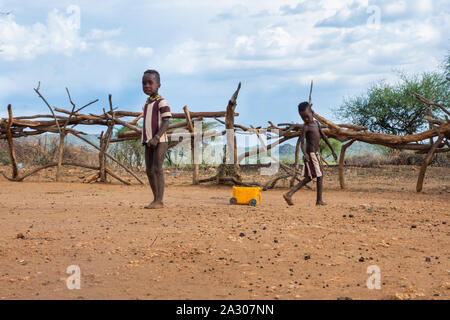 Turmi, Éthiopie - Nov 2018 : tribu Hamer enfants jouant avec de l'eau d'un camion en cartouche. Vallée de l'Omo Banque D'Images