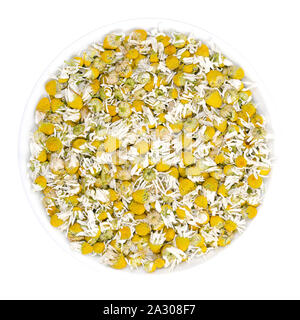 Fleurs de camomille séchées dans un bol blanc. Camomille, fleurs de Matricaria chamomilla, utilisé pour des infusions et en médecine traditionnelle. Banque D'Images