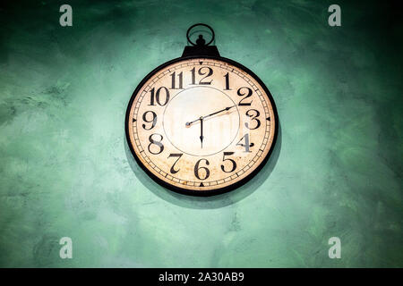 Old vintage watch avec pendaison le mur vert Banque D'Images