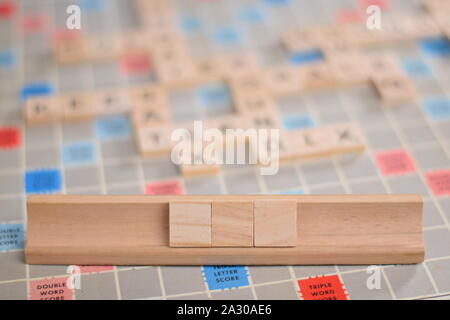 3 tuiles de SCRABBLE en bois blanc sur une tuile-rack, que vous pouvez remplir dans votre propre mot. Dans l'arrière-plan une carte vintage, des problèmes de mise au point, avec copie espace Banque D'Images