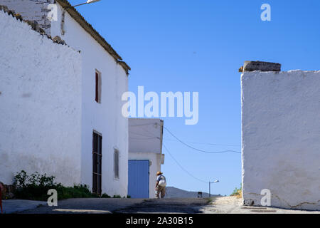 Vieil homme marchant à travers l'architecture mauresque dans la montagne village blanc de Comares, la Axarquía, Málaga, Andalousie, Costa del Sol, Espagne Banque D'Images