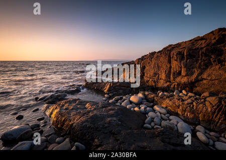 Des formations de roche côté allumé au coucher du soleil sur la côte nord du Devon à Westward Ho ! Banque D'Images