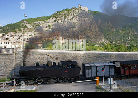 VUE AÉRIENNE depuis un mât de 6 mètres.Train à vapeur historique partant de la gare d'Entrouvaux avec fortification de la ville au sommet de la falaise.Entrevaux, France. Banque D'Images