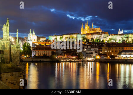 La nuit tombe sur la rivière Vltava à Prague, Tchéquie. Hradcany Castle dans la distance. Banque D'Images