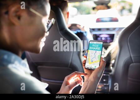 Femme africaine en utilisant le Car Sharing App While Sitting in Car Banque D'Images