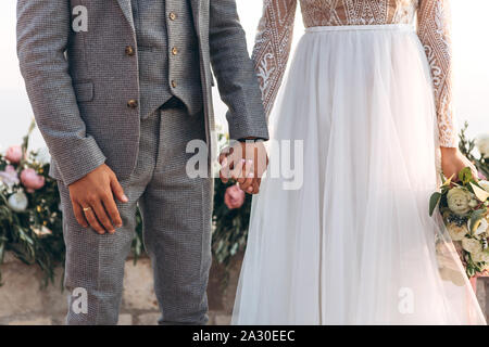 La mariée et le marié tenir la main pendant la cérémonie de mariage. Banque D'Images