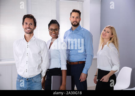 Portrait of Smiling Successful Business People Standing In Office Looking at Camera Banque D'Images