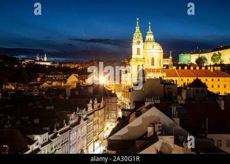 St Nicholas church towers sur Mala Strana de Prague, à la tombée de la nuit. Banque D'Images