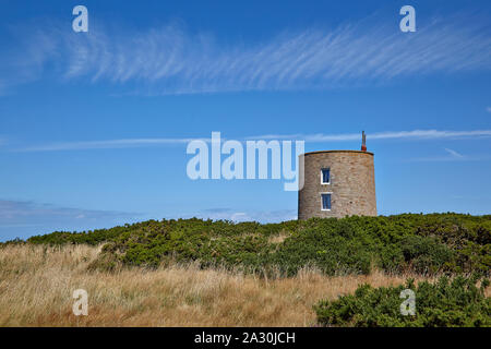 Paysage avec une maison convertie à partir d'une tour en pierre ronde, à l'origine un poste de garde en béton dans l'ancien camp de concentration allemand SS Lager Sylt Banque D'Images