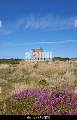 Paysage avec une maison convertie à partir d'une tour en pierre ronde, à l'origine un poste de garde en béton dans l'ancien camp de concentration allemand SS Lager Sylt Banque D'Images