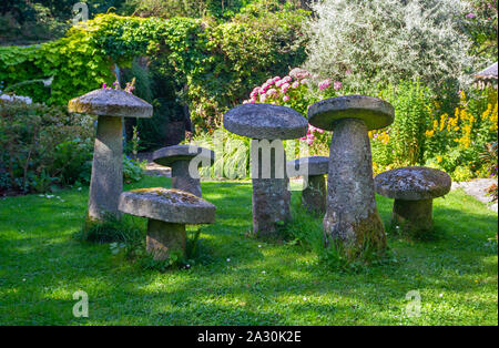 Sept pierres ornementales, pierre staddle toadstools, dans bien allumé jardin d'été. Vieux, conte de pierres couvertes de lichen et de mousse. L'Irlande Banque D'Images