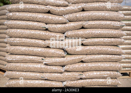 Pile de sacs en plastique avec plein de granulés de bois dans un marché Banque D'Images