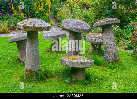 Pierre anciens pierres ornementales, staddle toadstools, en jardin d'été. Vieux, érodés, sept pierres couvertes de lichen et de mousse. Pierres de champignons Banque D'Images