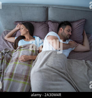 Jeune couple est en train de dormir dans leur lit. Banque D'Images