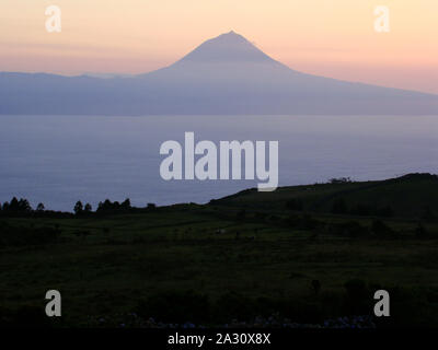 Silhouette de volcan de Pico dans l'archipel des Açores (Portugal), Mid-Atlantic, vu de l'île de Sao Jorge voisins au coucher du soleil Banque D'Images