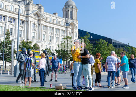 Des statues en bronze des quatre Beatles à Liverpool, UK et un couple gay qui prennent les selfies avec eux. Montre la diversité parmi les fans de la bande. Banque D'Images