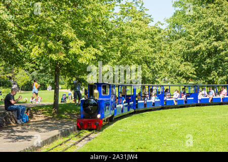 Les gens et les vacanciers à cheval sur le chemin de fer miniature en Train Pavilion Gardens Buxton Derbyshire, Angleterre Banque D'Images