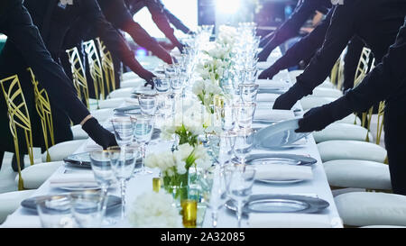 Grand groupe de serveurs servant un banquet. Banque D'Images