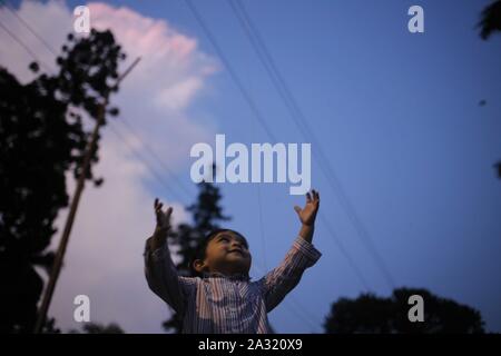 Dhaka, Bangladesh. 5ème Oct, 2019. Un jeu d'enfant avec un ballon sur une maison de vacances pendant le coucher du soleil près de la zone de l'université de Dacca. Credit : MD Mehedi Hasan/ZUMA/Alamy Fil Live News Banque D'Images