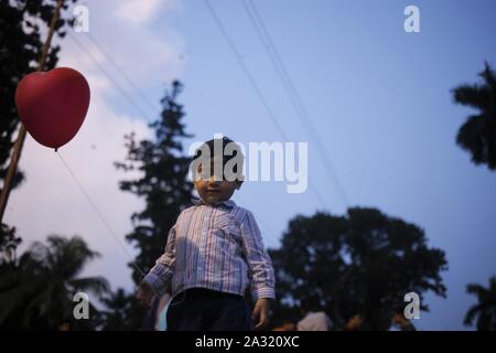 Dhaka, Bangladesh. 5ème Oct, 2019. Un jeu d'enfant avec un ballon sur une maison de vacances pendant le coucher du soleil près de la zone de l'université de Dacca. Credit : MD Mehedi Hasan/ZUMA/Alamy Fil Live News Banque D'Images