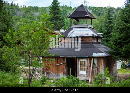 Une église en bois délabrées comme structure est vu dans un milieu rural à un défrichage camping sacrée parmi les arbres verts luxuriants avec copie espace. Banque D'Images