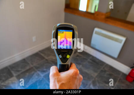 Une vue en gros plan sur la lunette arrière d'une caméra de vision thermique infrarouge, pointant vers le coin d'une pièce avec un sol froid et chaud isolation des murs. Banque D'Images